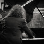 Joanna McGregor CBE Joanna MacGregor playing piano in black and white photo